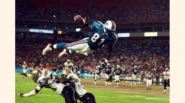 Randy McMichael - Saints vs. Dolphins - Agosto 15, 2002. El atacante de los Miami Dolphins Randy McMichael vuela sobre los defensas Michael Hawthorne y Mel Mitchell para anotar un "touchdown". (Foto: Learni)