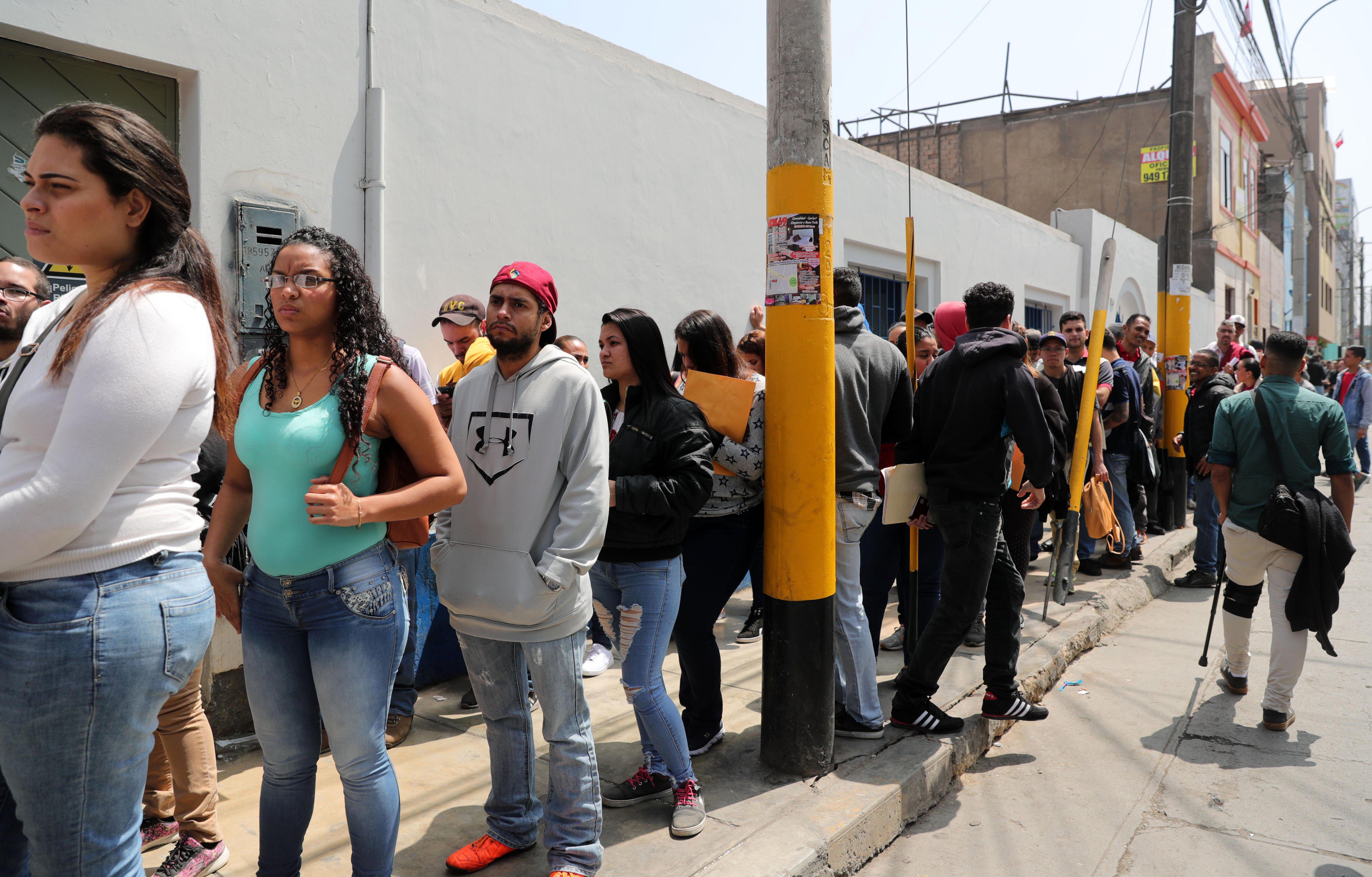 LIM03 - BREÑA (PERÚ), 20/8/2018.- Decenas de migrantes venezolanos hacen cola para tramitar el Permiso Temporal de Permanencia que les permita quedarse en el país hoy, 20 de agosto del 2018, en los exteriores de la Superintendencia Nacional de Migraciones de Lima (Perú). La organización no gubernamental Unión Venezolana en Perú entregó hoy una carta a la Cancillería de Perú para que evalúe el ingreso al país, sin pasaporte, de niños, mujeres gestantes, adolescentes, enfermos crónicos y ancianos venezolanos. EFE / Ernesto Arias