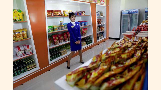 FOTO 1 | Una vendedora en una tienda de un complejo residencial recién construido en la calle Ryomyong tras su ceremonia de inauguración, Pyongyang.