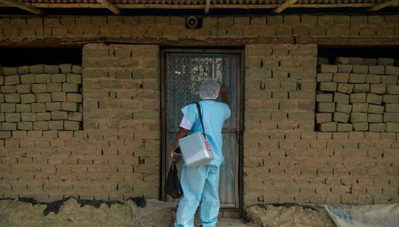 Un trabajador de la salud toca una puerta en Piura, al norte de Perú, durante el proceso de vacunación antiCOVID de la población. Foto: Ernesto BENAVIDES AFP/Archivos