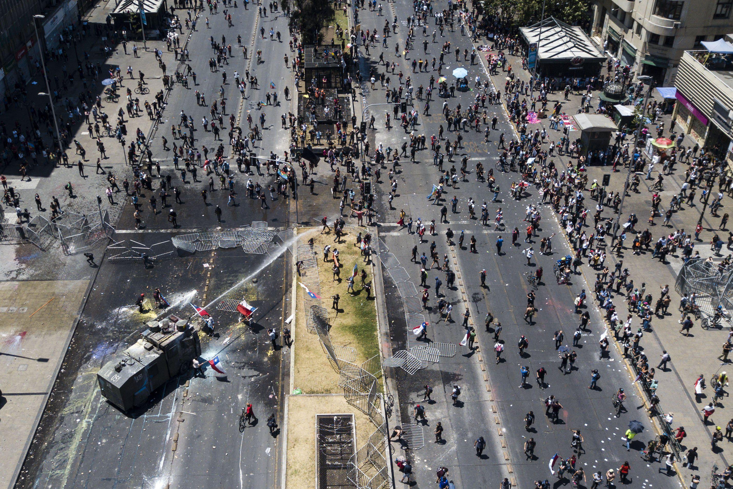 La policía usa cañones de agua para dispersar una protesta en Santiago. (AFP / JAVIER TORRES).