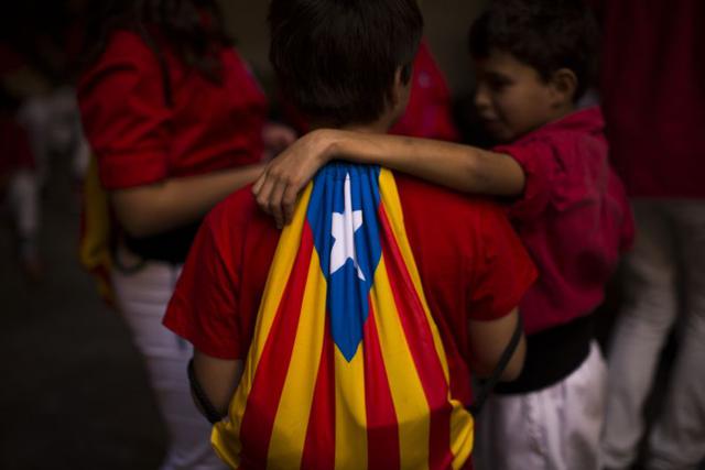 Niños catalanes, uno de ellos enfundado con la bandera de Cataluña, conversan en su idioma natal, el catalán. Los catalanes se enorgullecen de su lengua, cooficial junto con el español en la región de 7.5 millones de habitantes que limita con Francia. El 