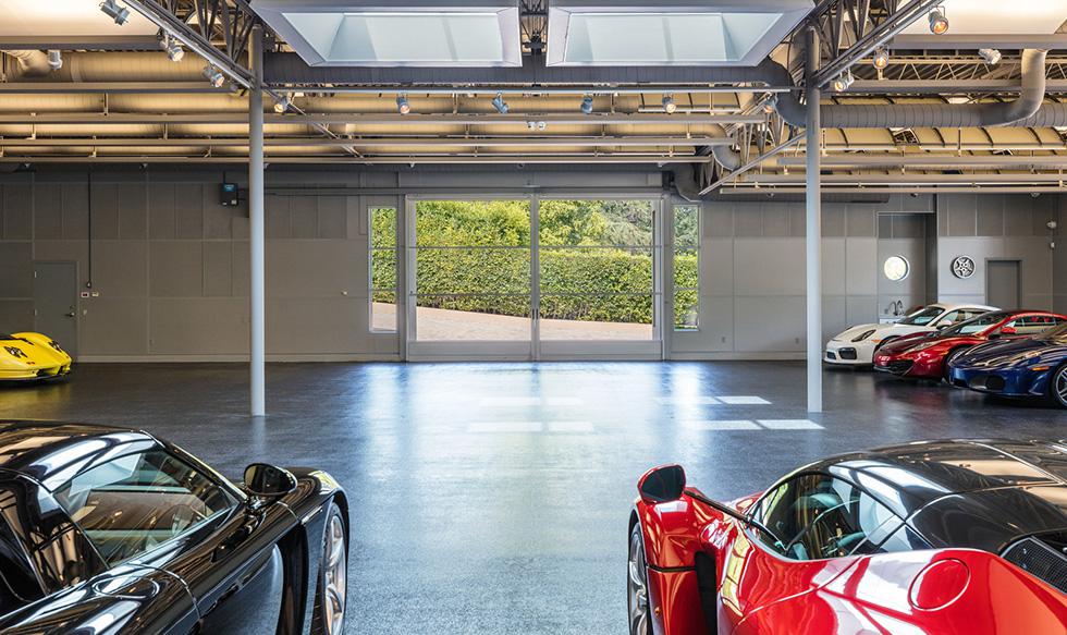 Foto 1 | Este garaje es de hecho una arena tipo museo con techos de 18 pies, ventanas de cristal de grado comercial, puertas antideslizantes y puertas de garaje que se abren a la entrada circundante. Un enorme tragaluz colocado en el centro del garaje destaca la colección de coches.