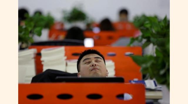 Cui Meng, cofundador del Grupo Goopal, toma una siesta en su escritorio después de almorzar en su oficina en Pekín, China. (Foto: Reuters)