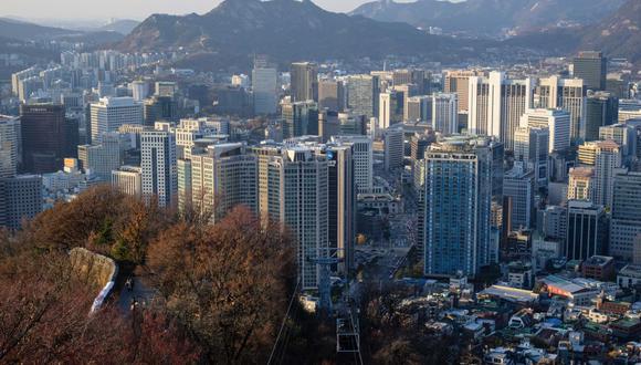 Vista general de los edificios más allá de los árboles en el follaje otoñal en Seúl. (Foto de ANTHONY WALLACE / AFP)