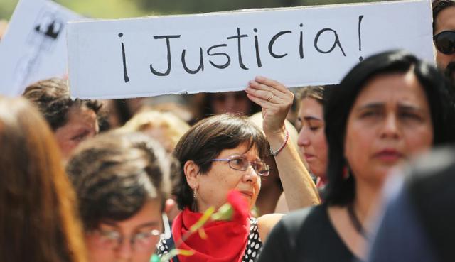 Una mujer sostiene un cartel que dice "¡Justicia!" durante una marcha hacia el palacio presidencial de La Moneda en Santiago. (Foto: EFE)