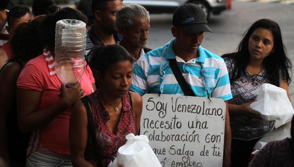 Venezolanos reciben ayudas fuera de la terminal de transporte de Cali. (Foto: EFE):