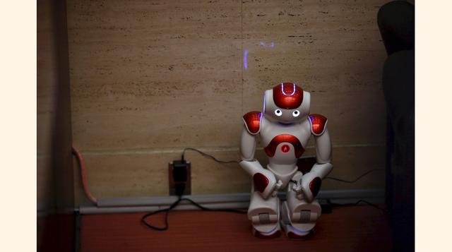 El Inventor chino Tao Xiangli controla con un mando a distancia su robot humanoide que fabrica en su casa en Beijing. (Foto: Reuters)