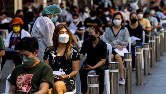 La gente hace cola para las pruebas de coronavirus, mientras los trabajadores de la hostelería y el turismo son evaluados en Khao San Road, en Bangkok, el 6 de enero de 2022. (Foto de Jack TAYLOR / AFP)