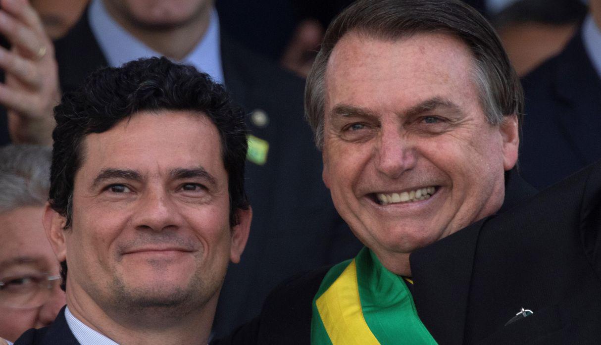Jair Bolsonaro saluda a los asistentes a un desfile acompañado por el ministro de Justicia, Sergio Moro. (Foto: EFE)