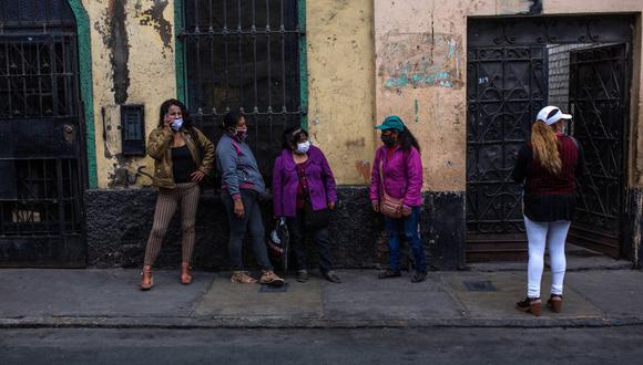 Trabajadoras sexuales esperando para recoger una ración de la olla común solidaria de la Asociación Miluska en la casona en el Cercado de Lima (Perú). (Foto: EFE/Sergi Rugrand)