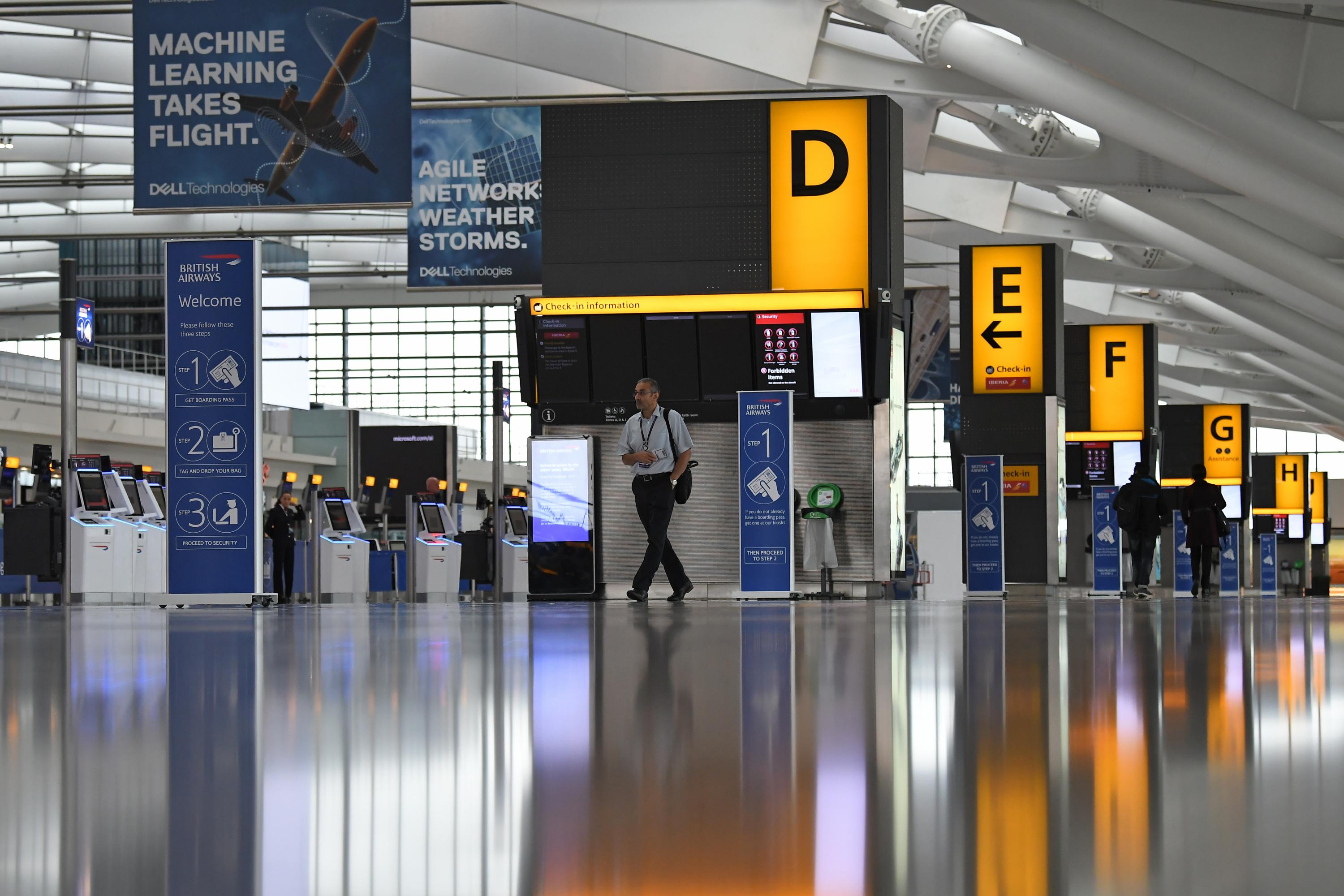 Unos pocos pasajeros caminaron alrededor del área de salida casi desierta en la Terminal 5 del aeropuerto de Heathrow en el oeste de Londres. (Foto: AFP)