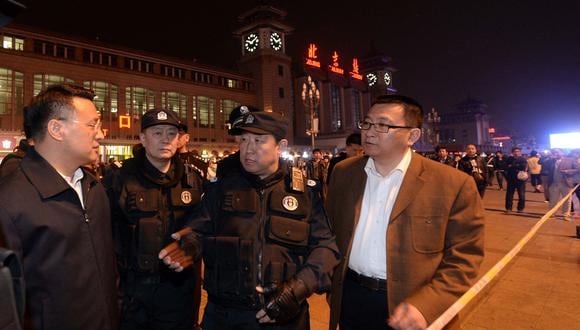 Esta fotografía tomada el 6 de mayo de 2014 muestra al viceministro chino de seguridad pública, Fu Zhenghua (centro), hablando en la estación de tren de Beijing. (Foto: AFP)
