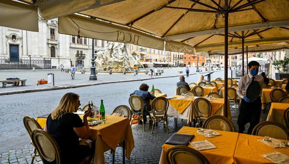 Personas almuerzan en la terraza de un restaurante de la Plaza Navona en Roma, el 18 de mayo de 2020. (AFP)
