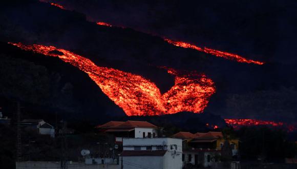 Lava fluye detrás de las casas en Los Llanos mientras el volcán Cumbre Vieja continúa en erupción en la isla canaria de La Palma, visto desde Tajuya, España. (Foto: Reuters)