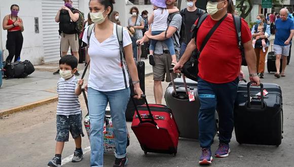 Canadienses fuera del consulado de su país en Lima, antes de abordar autobuses que los llevarán al aeropuerto Jorge Chávez para ser repatriados, tras el cierre de fronteras ordenado por Perú debido a la pandemia de coronavirus, el 26 de marzo de 2020. (Foto: Cris BOURONCLE AFP)