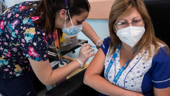 Una trabajadora sanitaria recibe la vacuna contra el coronavirus en el Hospital de Urgencia Asistencia Pública en Santiago (Chile), el 24 de diciembre de 2020. (EFE/Alberto Valdes).