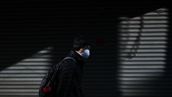 Un hombre camina por una calle en el área de Tsukiji en Tokio. Japón dijo el 17 de febrero que cancelaría una reunión pública para celebrar el cumpleaños del nuevo Emperador Naruhito el 23 de febrero, a medida que crecen los temores sobre la propagación del nuevo coronavirus.  (AFP)