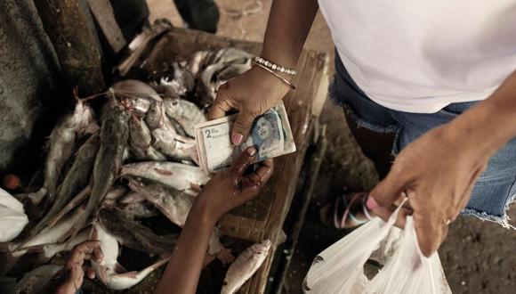 Una transacción de dinero en el mercado de alimentos de Riohacha, Colombia, el sábado 13 de agosto de 2022.