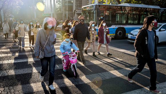 Personas usan mascarillas por el coronavirus Covid-19 en una calle de Beijing. (Foto: AFP/Nicolás Asfouri)