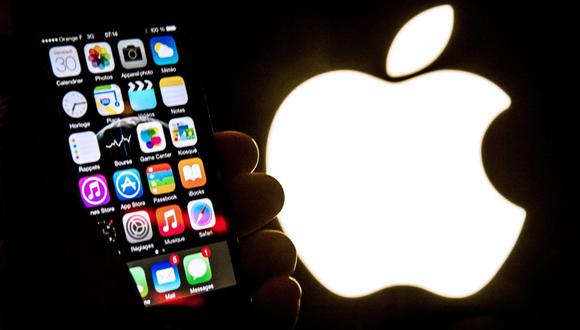 Una ilustración de un iPhone sostenido frente al logotipo de Apple Inc. tomada el 30 de enero de 2015 en Lille (Foto: Philippe Huguen / AFP)