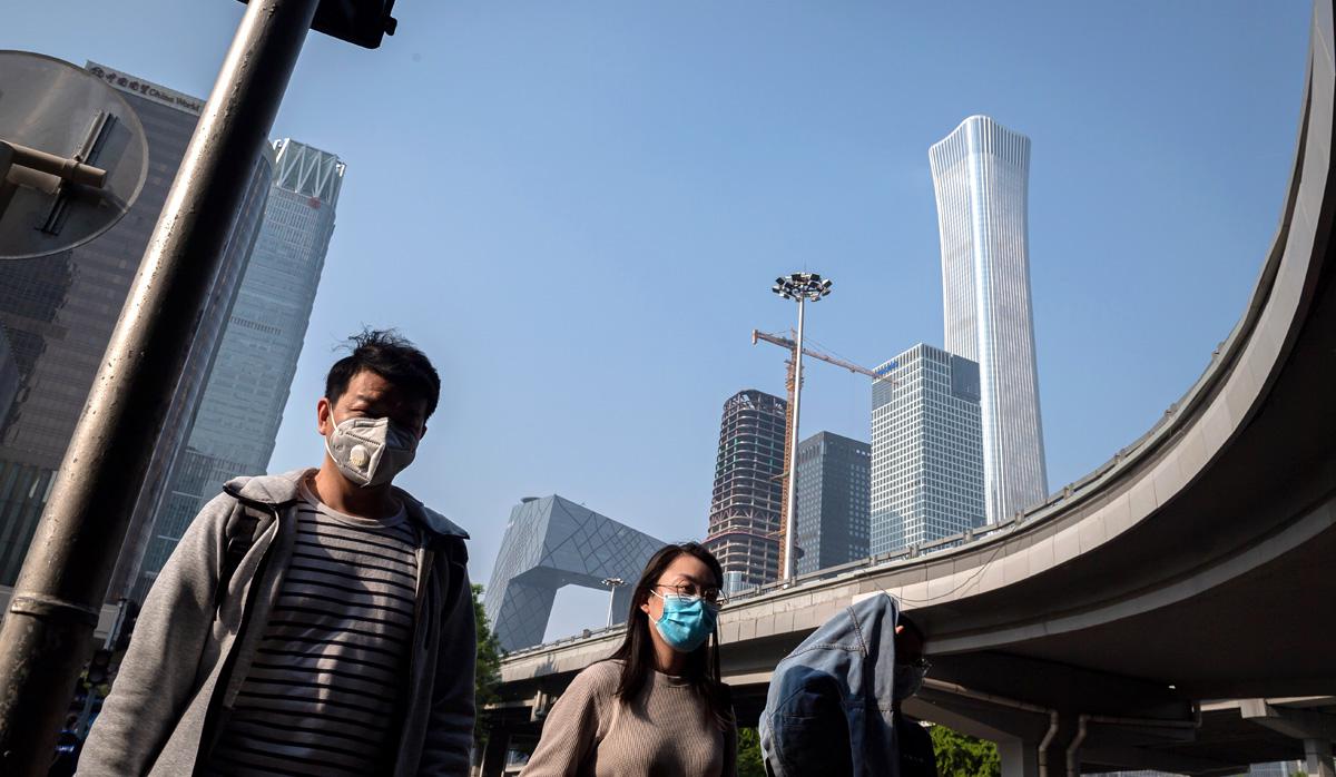 Personas con mascarillas en medio de preocupaciones por el coronavirus COVID-19 caminan por una calle en Beijing. (Foto: AFP/NICOLAS ASFOURI)