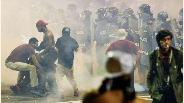 La gente corre ante las granadas de humo que lanza la Policía. (foto: reuters).
