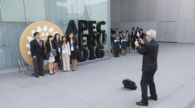 Asistentes al APEC se toman fotografías en los exteriores de las sedes del foro (foto: Andina).