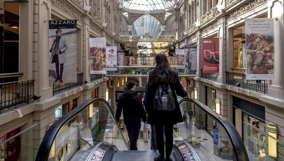 Los compradores suben por una escalera mecánica en el centro comercial Galerías Pacífico en Buenos Aires, Argentina, el miércoles 24 de agosto de 2022.