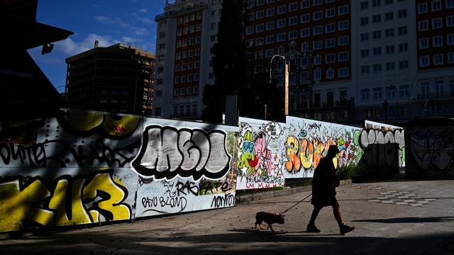 Imagen referencial. Una mujer pasea a su perro en la Plaza de España en Madrid, el 24 de abril de 2020. (Gabriel BOUYS / AFP).