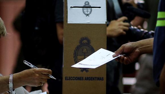 Una hombre recibe un sobre para emitir su voto en las elecciones presidenciales de Argentina. (Foto: EFE)