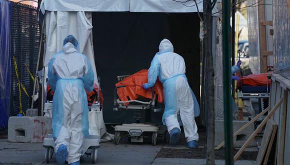 Bodies are moved to a refrigerator truck serving as a temporary morgue outside of Wyckoff Hospital in the Borough of Brooklyn on April 4, 2020 in New York. - New York state's coronavirus toll rose at a devastating pace to 3,565 deaths Saturday, the governor said, up from 2,935 the previous day, the largest 24-hour jump recorded there. (Photo by Bryan R. Smith / AFP)