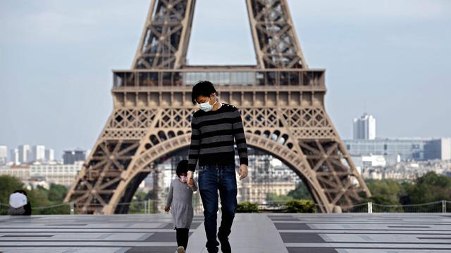 Imagen referencial de dos personas en inmediaciones de la Torre Eiffel en París. El coronavirus causó 24.594 muertos en Francia, según el último balance oficial comunicado el viernes por la noche. (AFP / THOMAS COEX).