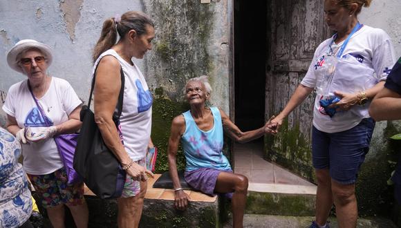 Zuleida saluda y habla con trabajadores sanitarios municipales y voluntarios que inspeccionan la favela de Tabajara. Foto: AP
