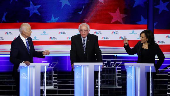 la senadora Kamala Harris (R) (D-CA) y el ex vicepresidente Joe Biden (L) hablan mientras el senador Bernie Sanders (I-VT) observa durante la segunda noche de la primera presidencia demócrata. Foto: AFP