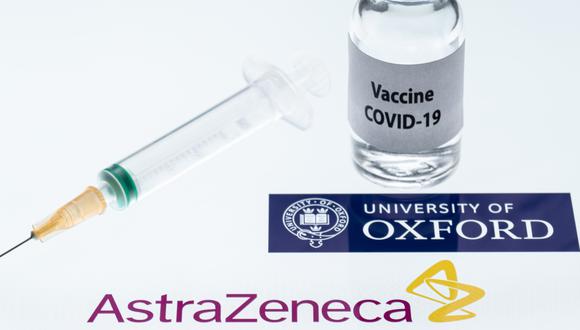 Esta fotografía de ilustración tomada en París el 23 de noviembre de 2020 muestra una jeringa y un frasco que dice "Vacuna COVID-19" junto a los logotipos de la empresa AstraZeneca y de la Universidad de Oxford. (JOEL SAGET / AFP).