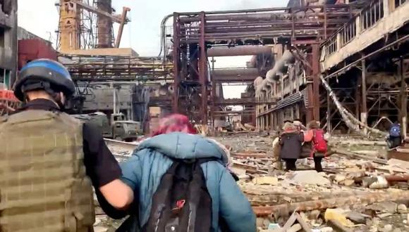 Miembros del Regimiento Azov caminan junto a civiles durante la evacuación liderada por la ONU de las ruinas de la acería Azovstal tras dos meses de bombardeos por parte de las fuerzas rusas, en Mariúpol, Ucrania, en esta captura obtenida de un vídeo cedido publicado el 1 de mayo de 2022. (Foto: David Arakhamia/Regimiento Azov/Cedida a través de REUTERS)