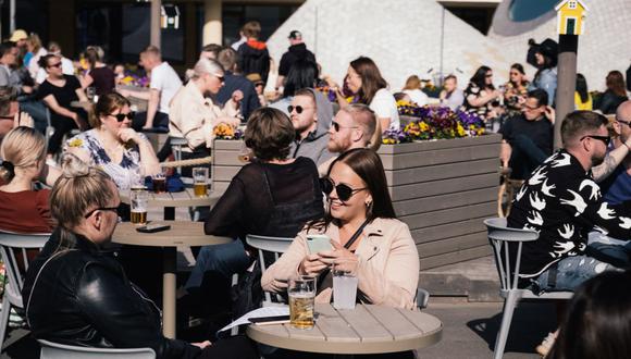 La gente disfruta de una bebida mientras está sentada en una terraza en Helsinki el 1 de junio de 2020. (Foto de Alessandro RAMPAZZO / AFP)