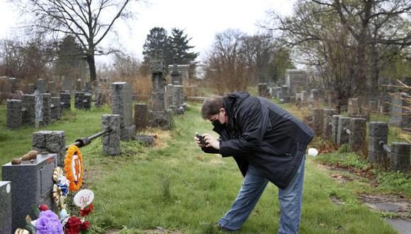 Brian Walter toma una foto de la tumba de su padre John Walter en el All Faiths Cemetery del distrito neoyorquino de Queens. (Foto: AP)