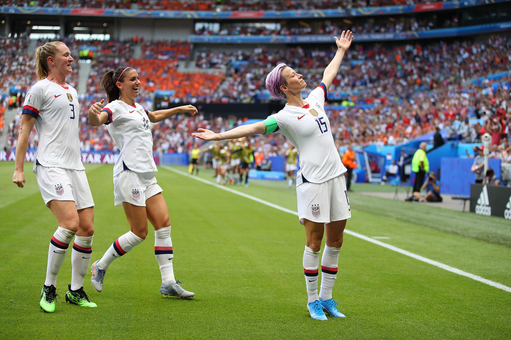 LYON, FRANCE - JULY 07:  Megan Rapinoe of the USA celebrates with teammates Alex Morgan and Samantha Mewis after scoring her team's first goal during the 2019 FIFA Women's World Cup France Final match between The United States of America and The Netherlands at Stade de Lyon on July 07, 2019 in Lyon, France. (Photo by Richard Heathcote/Getty Images)