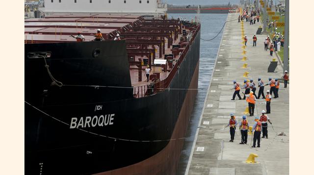 Cientos de obreros con cascos coloridos se agolparon en la orilla de la vía para tomarse fotos al paso del buque. (Foto: AP)