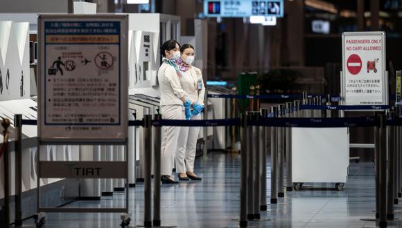 Personal se para en la puerta de salida del aeropuerto internacional Haneda de Tokio el 29 de noviembre de 2021, cuando Japón anunció planes para prohibir la entrada de nuevos viajeros extranjeros debido a la variante ómicron del coronavirus. (Philip FONG / AFP).