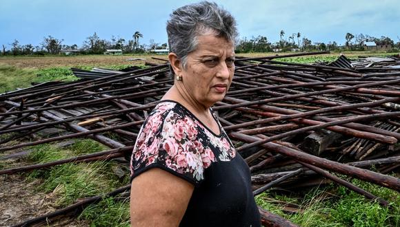 La propietaria de una finca de tabaco, Maritza Carpio, llora y su esposo, Ramón Martínez, miran su casa de tabaco destruida tras el paso del huracán Ian en San Luis, Cuba, el 27 de septiembre de 2022. . (Foto de ADALBERTO ROQUE / AFP)