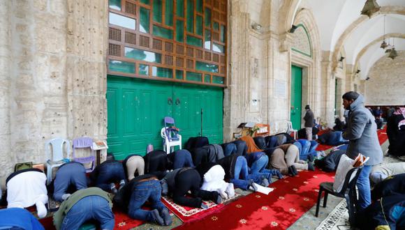 Los musulmanes palestinos se reúnen para realizar sus oraciones del viernes frente a las puertas cerradas de la mezquita Al-Aqsa en la Ciudad Vieja de Jerusalén. (Foto: AFP)