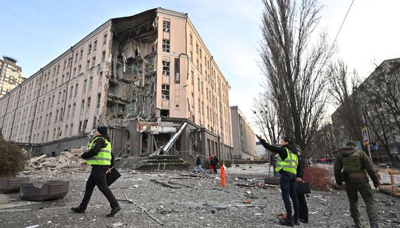 Rescatistas y policías trabajan en la parte inferior de un hotel, que fue parcialmente destruido por un ataque ruso en el centro de la capital ucraniana, Kyiv, el 31 de diciembre de 2022. (Foto de Sergei SUPINSKY / AFP)