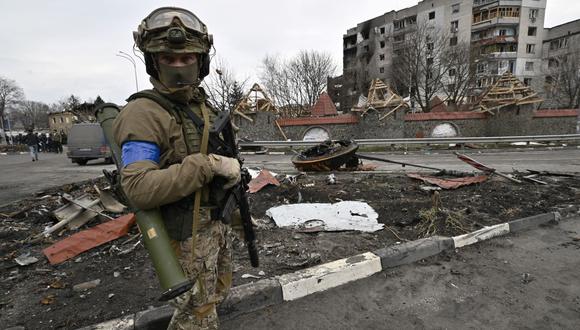 Un militar ucraniano hace guardia en una calle al lado de un edificio dañado en la ciudad de Borodianka, al noroeste de Kiev, el 6 de abril de 2022. (Genya SAVILOV / AFP).