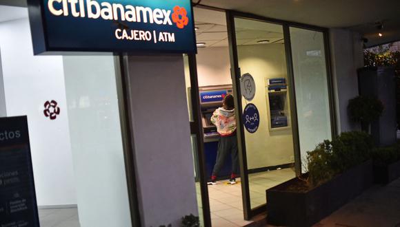 Una mujer retira dinero de un cajero automático de Citibanamex en la Ciudad de México, el 11 de enero de 2022. (Foto de RODRIGO ARANGUA / AFP)