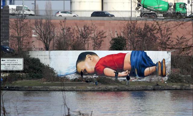 Frankfurt, Alemania. Un mural, por Justus Becker y Oguz Sen, representa al niñsirio ahogado Alan Kurdi, cerca de la sede del Banco Central Europeo en 2016. Fue creado para poner de relieve la difícil situación de los refugiados. (Foto: AFP)