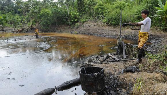 Empleados de la estatal Petroecuador trabajan en operaciones de limpieza ambiental de un derrame de petróleo de hace 30 años en la comuna de Rumipamba, a 200 tm del pozo petrolero Auca Sur 1. (Foto de RODRIGO BUENDIA / AFP)