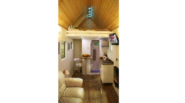 Por dentro es realmente una acogedora casa rural que incluye elementos esenciales como una sala de estar, baño y cocina.